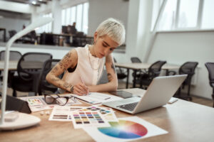 Young and beautiful creative female designer making a sketch while sitting at her workplace in the office. Web design. Creative occupation. Business and career. UX UI design